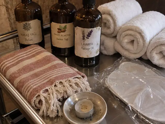 Masaj yağı şişeleri, rulo havlular ve pembe peştemal — Gürpınar, Masaj Salonun